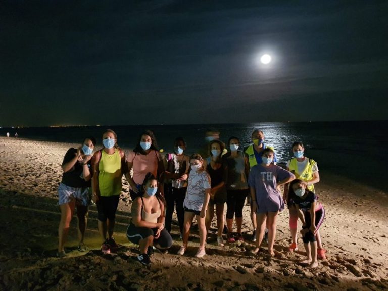 Un centenar de personas caminan bajo la luna llena por las playas de Isla Cristina