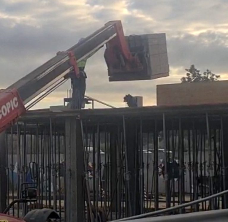 Un palé de adoquines se desploma desde una grúa junto a las aulas del colegio de El Rompido